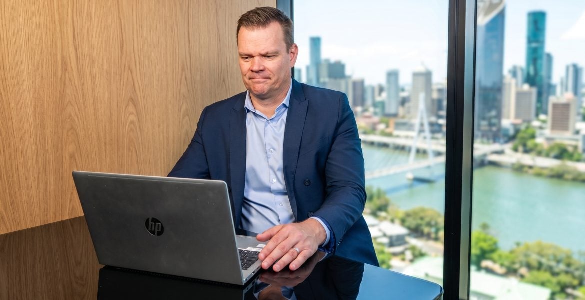 Brett Warren reviewing property market updates in a Brisbane office